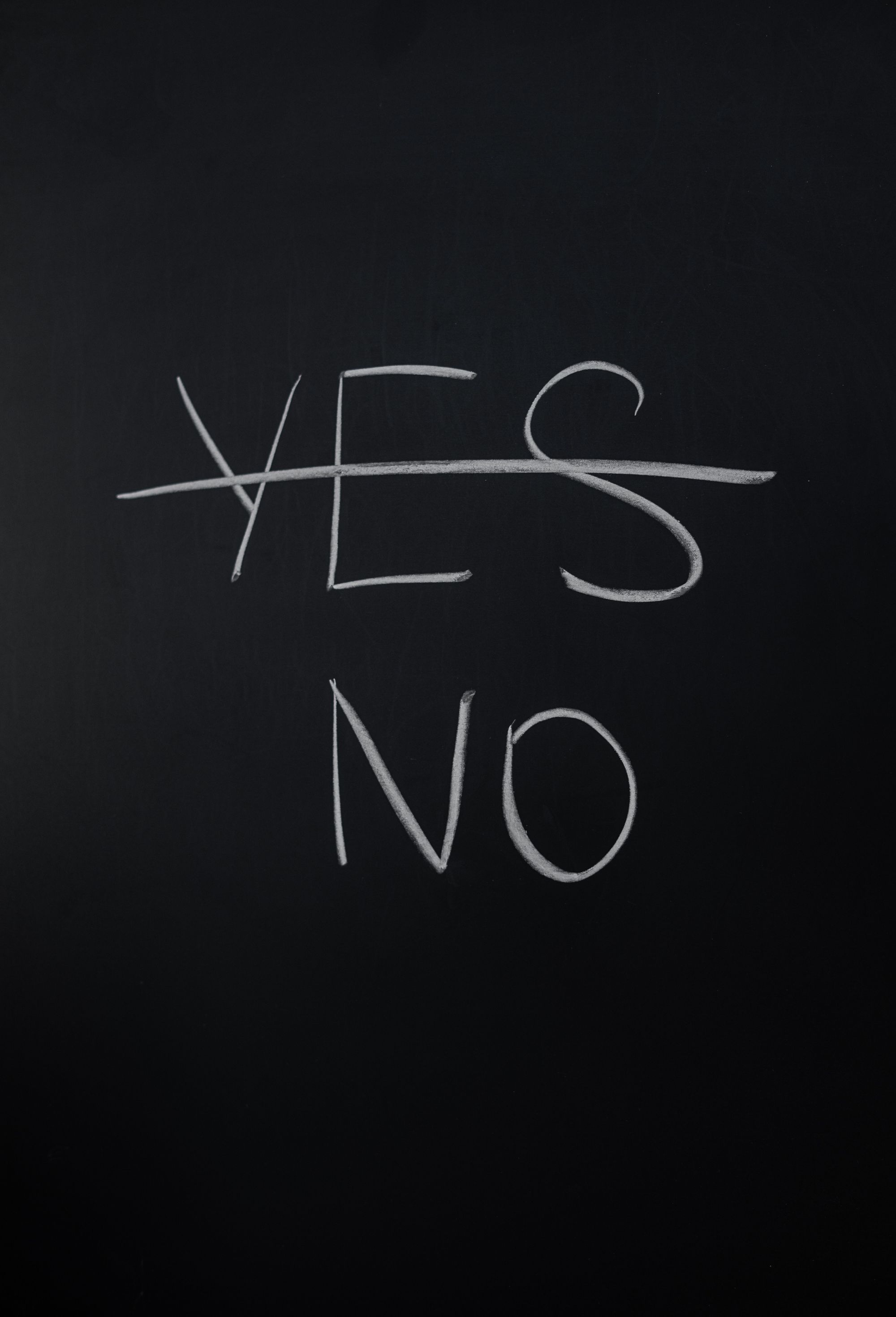 A chalkboard with the word "yes" crossed out and replaced with "no"