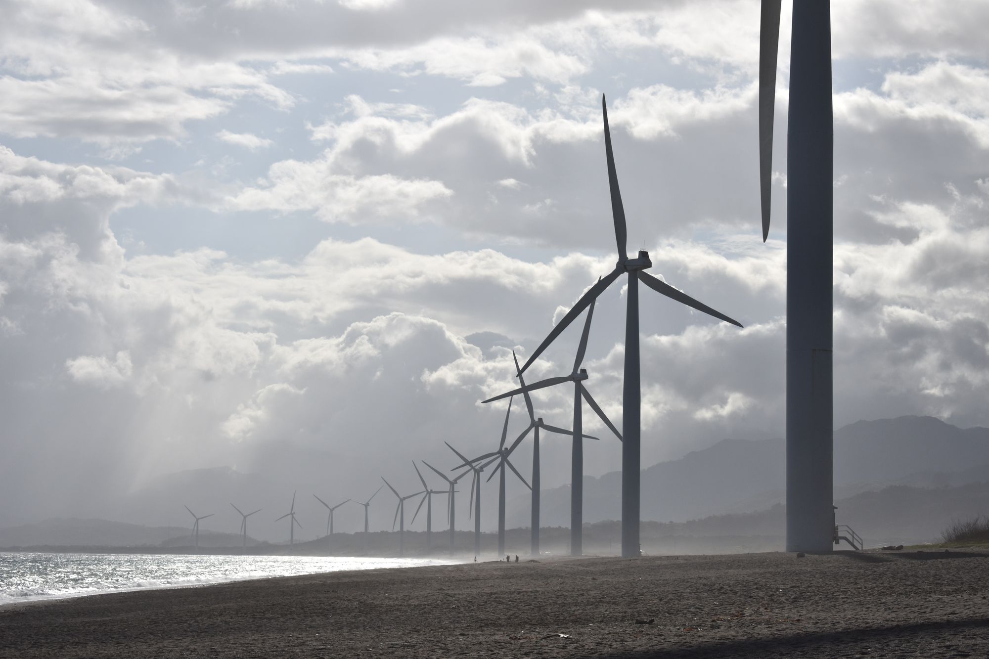 A line of wind turbines on a beach