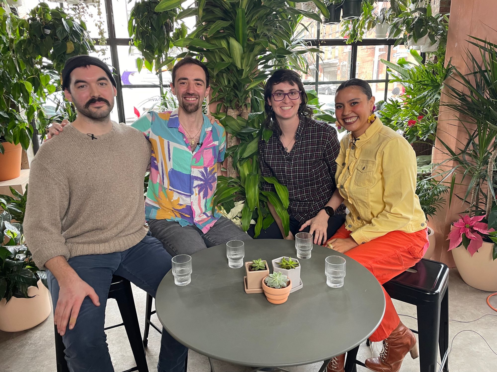 Four people sitting in a plant shop smiling